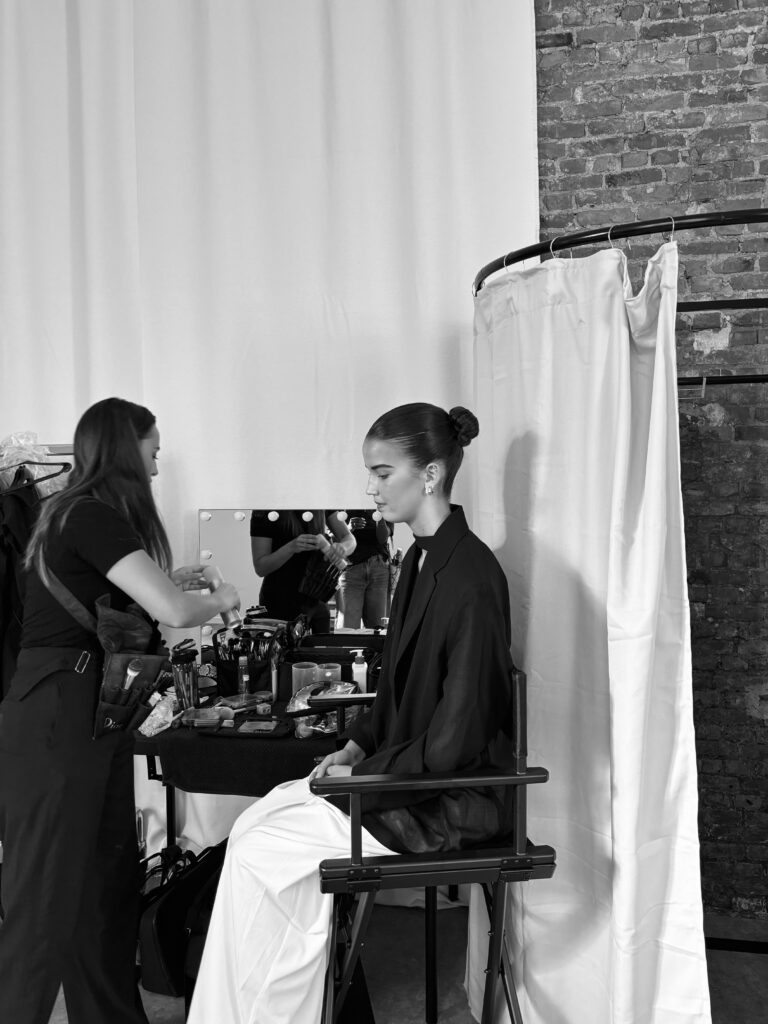 Backstage in the studio: a makeup artist preparing a model