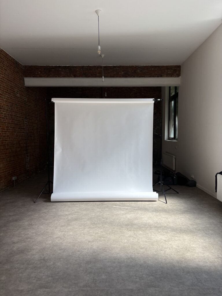 White paper backdrop at the far end of the studio